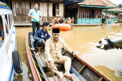 Naik Perahu, Pj H Apriyadi Tinjau dan Beri Bantuan Korban Banjir di Ulak Embacang