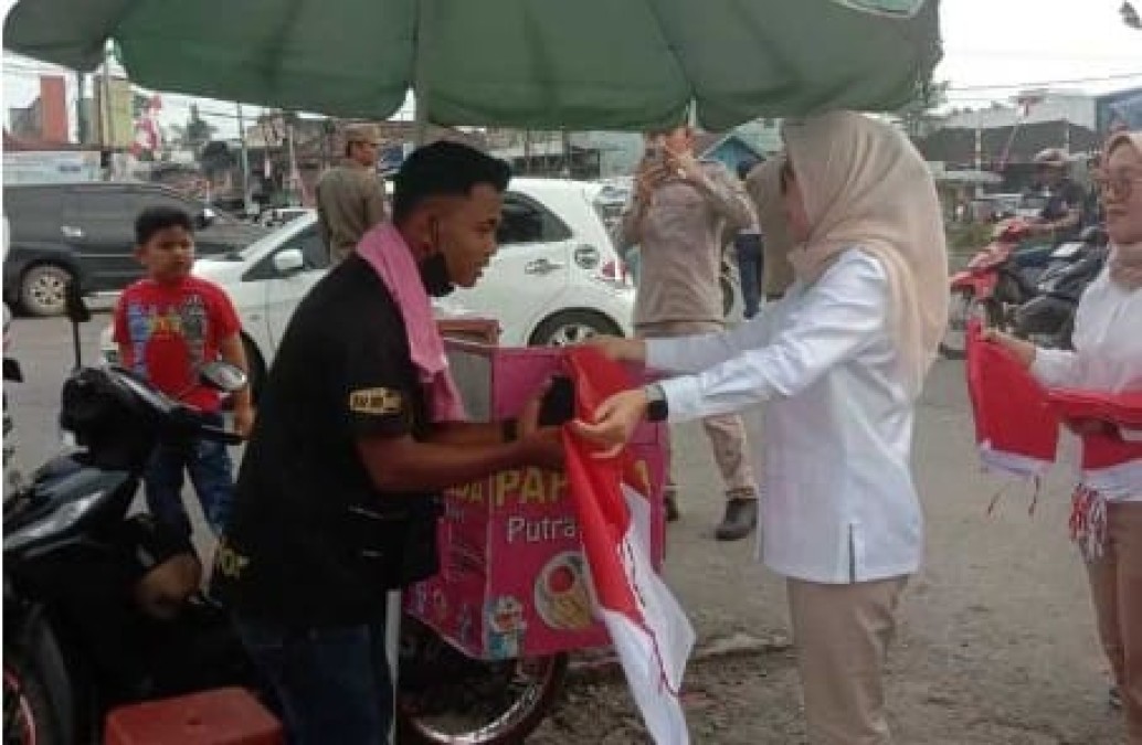 KETUA TP PKK PALI TURUN LANSUNG MEMBAGIKAN BENDERA MERAH PUTIH KEPADA MASYARAKAT DI KAWASAN SIMPANG LIMO TALANG UBI